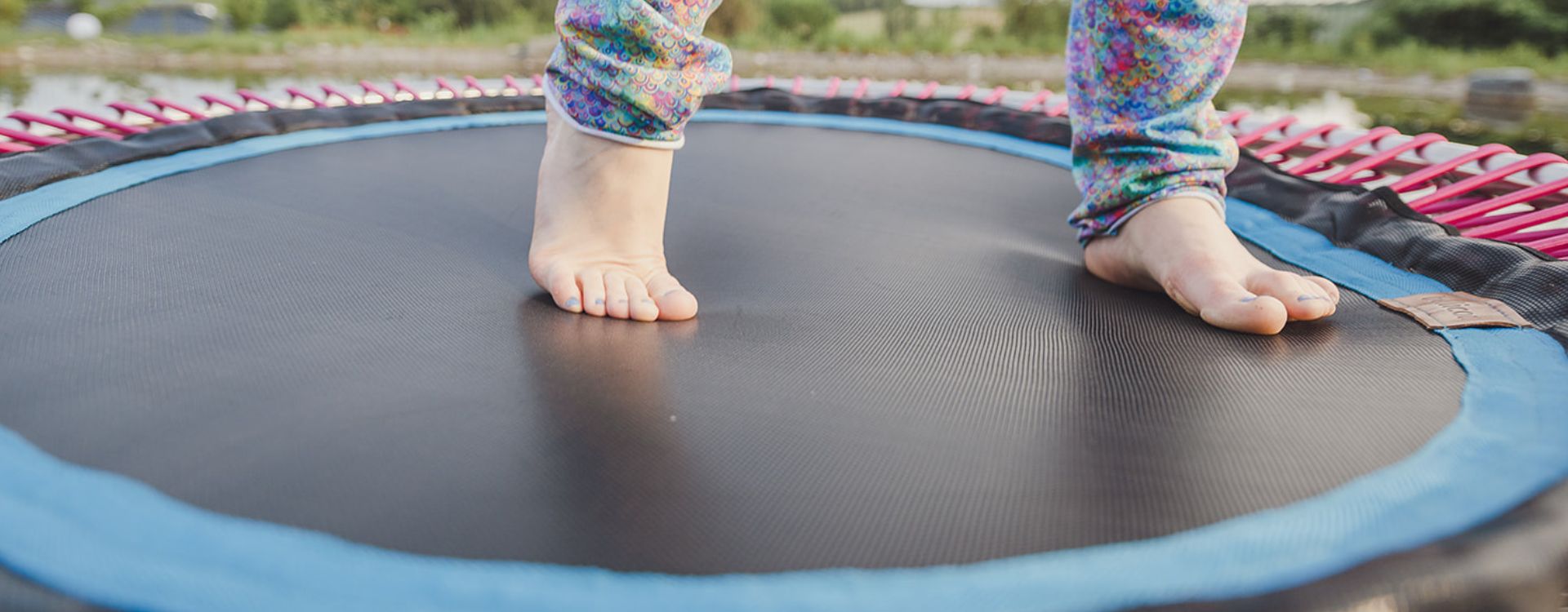 Barfuß auf der Sprungmatte eines bellicon Minitrampolins im Freien
